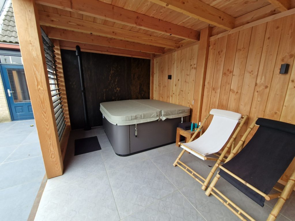 Wellness tuin met Douglas houten overkapping Breda met jacuzzi, buiten douche op keramische tegels met unieke wand & In-lite + spotjes