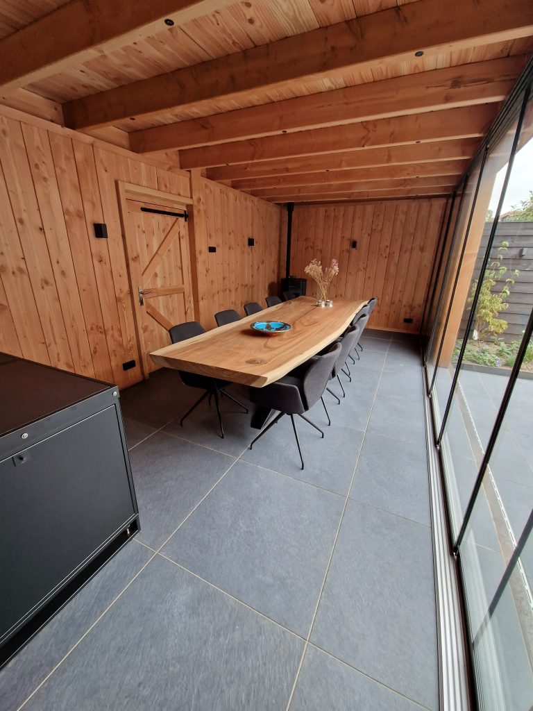 Douglas houten overkapping met binnen keuken, houtkachel, unieke houten tafel, shutters & glazenschuifpui