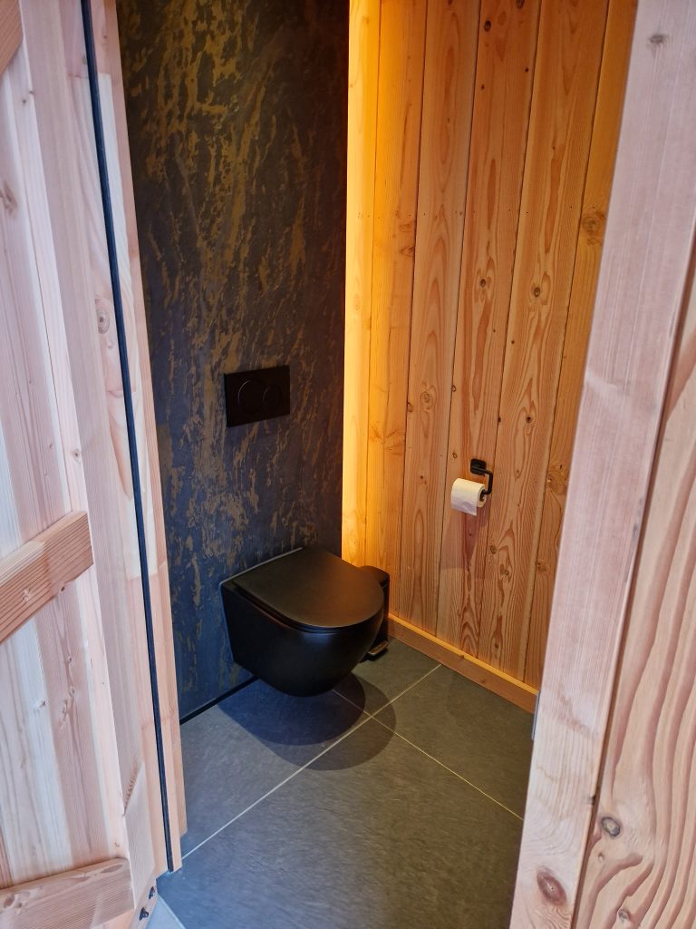 Toiletruimte binnen Douglas houten overkapping met unieke wand + spotjes