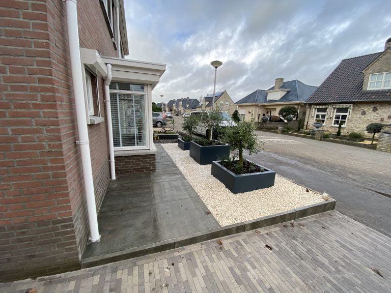 Luxueuze voortuin in St Willebrord met oprit, douglas houten palen, polyester bloembakken, grind & beplanting