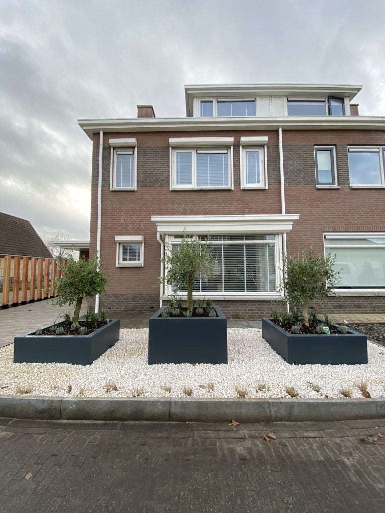 Luxueuze voortuin in St Willebrord met oprit, douglas houten palen, polyester bloembakken, grind & beplanting